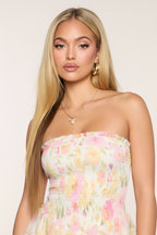 Close-up bodice detail of ivory floral chiffon strapless mini dress – strapless neckline smocked bodice with delicate floral fabric on blonde European model