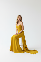 Yellow mermaid gown seated view – strapless ruched formal dress showing full silhouette